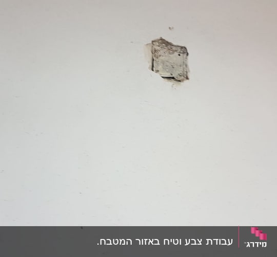 קיר לבן עם חור קטן במרכזו